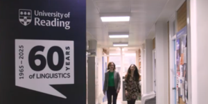 Staff in English Language Department corridor alongside 60 years banner