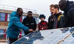 Built Environment students and staff looking at a solar panel